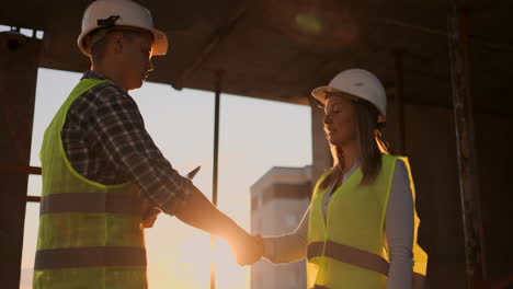 Female-architect-and-construction-worker-shaking-hands.-Low-angle-view-copy-space